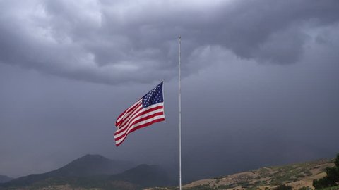 American Flag at half-mast blowing in the wind for death of an officer in the line of duty.