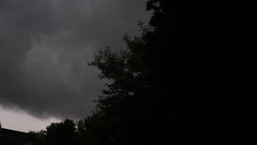 Stormy dark clouds gathering in moody sky over houses