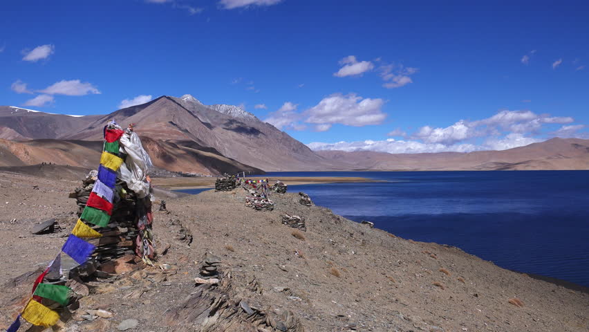 Tranquil meditative landscape of Tso Moriri Lake and Buddhist stupa ( chorten ) made from stones by nomad Tibetan people decorated with praying flags. Himalaya mountains range. India, Ladakh
