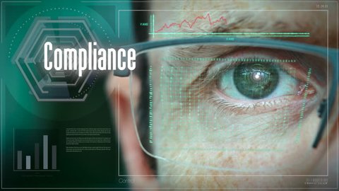 A close up of a businessman eye controlling a futuristic computer system with an Compliance concept.