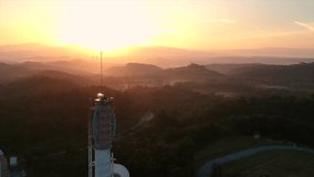 Aerial view of Telecommunication tower of cell phone antenna during sunrise. Shoot from drone. 4K video
