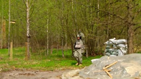 Moscow, Russia - May 09, 2013: Men in military uniforms playing in ruined building of airsoft military polygon. People using a copy of a firearm.