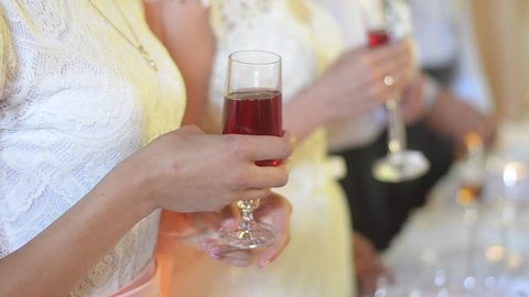 Woman with a glass in her hands applauding. Hands of the guest at the wedding. Camera flashes. Toast. Wedding reception. Closeup shot.