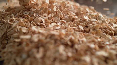 Camera follows throwing oats over a pile of oats. Shot with high speed camera, 4K. Slow Motion.
