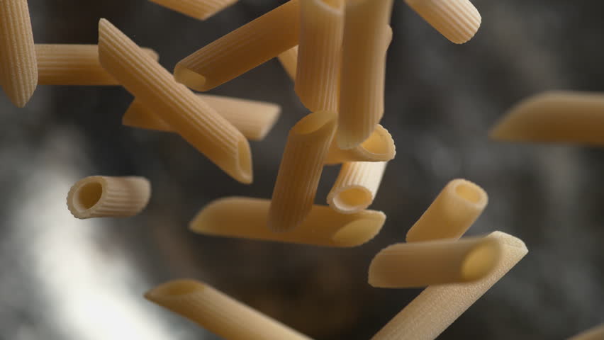 Camera follows throwing penne pasta into water. Overhead shot. Shot with high speed camera, 4K. Slow Motion. Royalty-Free Stock Footage #1015533160