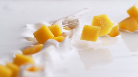 Tossing diced mango in yoghurt. Shot with high speed camera, 4K. Slow Motion.