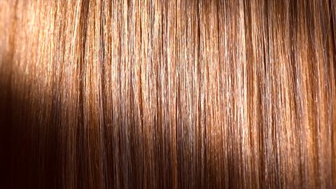 Hair. Beautiful healthy long smooth flowing brown hair close-up texture. Dyed straight hair background, coloring, extensions, cure, treatment concept. Haircare. Slow motion 4K UHD video