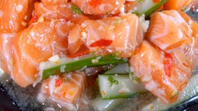 Salmon sashimi spicy salad on black dish in the restaurant (Japanese food)