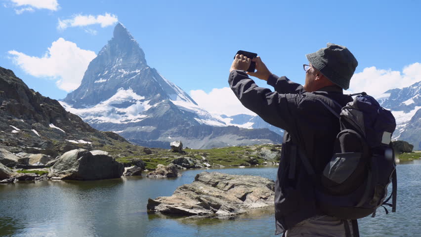 Old Man Taking Pictures With Mobile Smartphone Of Mountain and Landscape