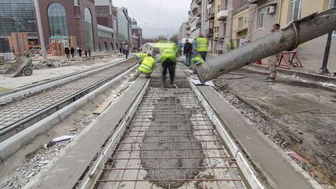 Pouring ready-mixed concrete after placing steel reinforcement to make the road by concrete mixer timelapse hyperlapse. Reconstruction of tram tracks