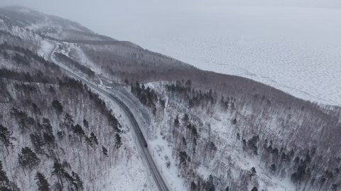 Dramatic winter Aerial drone follow Trans-Siberian railway passengers tourist train on beautiful Baikal. Cinematic professional 4k footage. Cold snow Siberia Russia best journey. High altitude