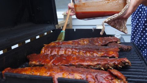 Amazing and delicious racks of ribs cooking on a hot and smokey barbecue