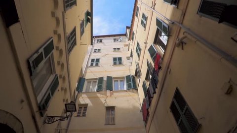 Beautiful panoramas are taken to the drone of narrow streets in a small European Italian French town by the sea. colored houses. Video in motion. Blue sky. French Riviera. Ancient houses and streets 