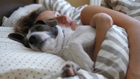 Young Woman Sleeping With Dog In Bed.