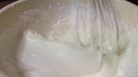 Making whipped cream by hand with whisk.