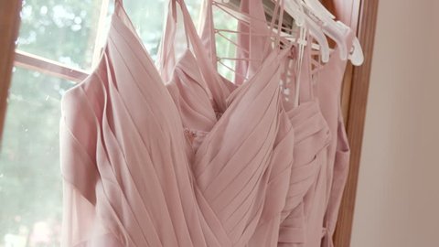 Bride Bridesmaids Dresses Hanging in Front of Window Before Ceremony