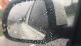 view of road and country side from side mirror when driving car in the rain