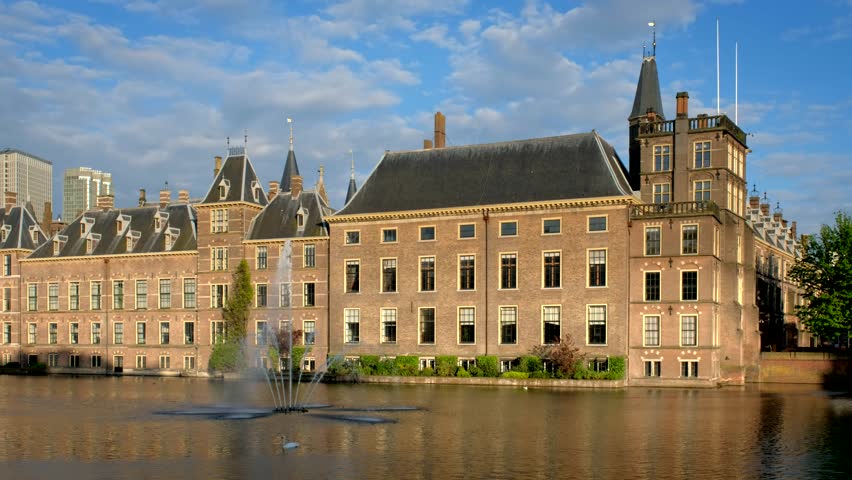 View of the Binnenhof House of Parliament and the Hofvijver lake with downtown skyscrapers in background. The Hague, Netherlands