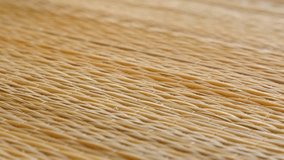 Brown texture of beach straw mat close-up 4K tilting footage