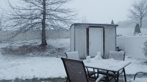 Snow falling in super slow motion from a backyard