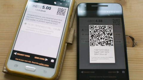 Sending Bitcoin between smartphones by scanning QR code, future of retail transaction in shop, digital cash concept