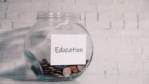UK Money Jar on a white shelf in a household living room. Saving for Education Concept
