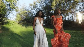 Daytime slow motion shot of two beautiful African American women walking in a park in Los Angeles