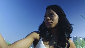 Slow Motion shot of an African American woman taking a sefie with Downtown Los Angeles in the background