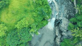 Aerial footage of the wonderful waterfall with river foaming water, great rocks and green plants on Bali Indonesia, travel world shooting video 4K from the aircraft from above, awesome landscape view