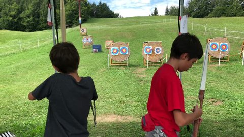 Young archery kids outdoors.
