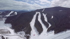 Aerial drone shootage of winter park in Carpathian mountains shot from above with flying video camera in dull cold day