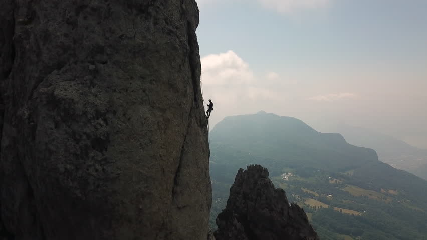 drone view of two person climbing a rock