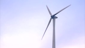 A video of a rotating windmill against the sky.
