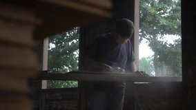 Carpenter working with electric planer on wooden plank, video, slow motion, selective focus