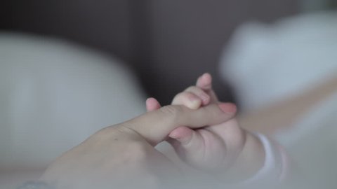 Close-up shot of baby and mother hands. Child holding mom finger. Parent and kid love and bonding Video stock