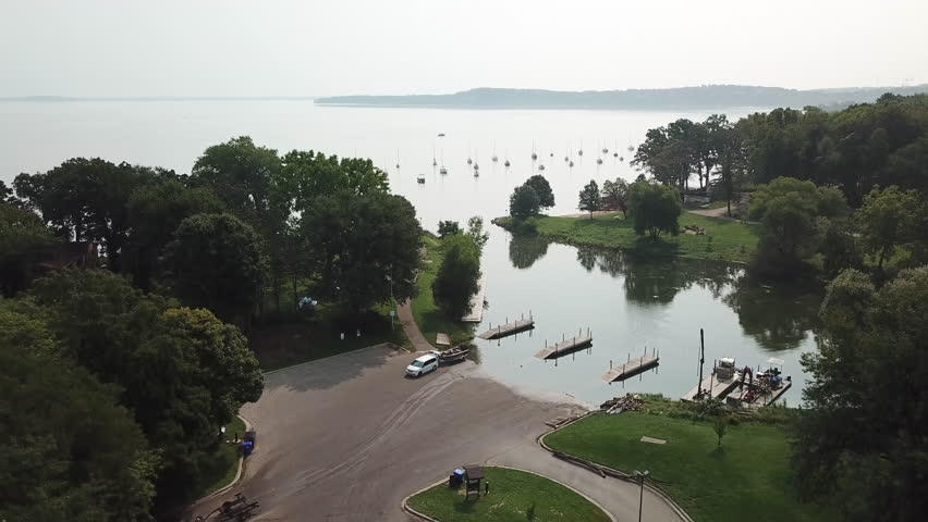 Flight Take Off and Fly Towards Sailboats on Lake