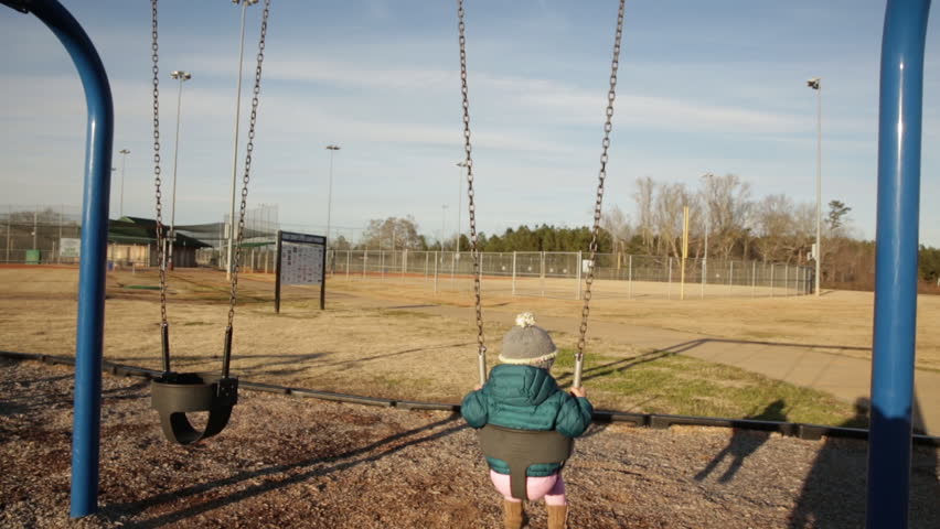 Little Girl Swinging from Behind in Winter Clothes