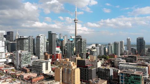 Aerial view of Toronto cityscape including modern high rise buildings and the iconic CN Tower by day during summer in Toronto, Ontario, Canada.