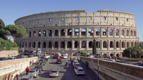 ROME, ITALY - CIRCA May 2018: Panorama of famous attraction Colosseum in Rome, Italy. Veiw from road on ancient Flavius amphitheater Coliseum. Tourists walking and cars passing by