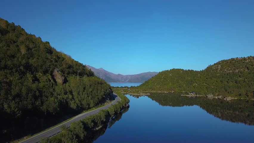 Aerial view of road by the lake, fjord and mountains. Beautiful Nature Norway. Lofoten Islands. 4k