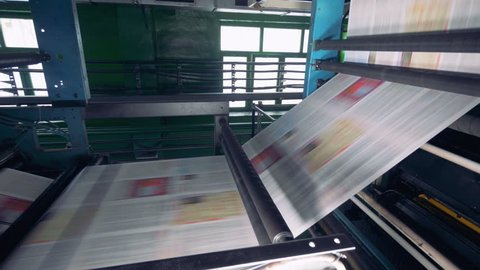 Fresh printed newspaper, magazines moving on a line at a printing office.