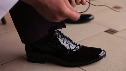 Businessman Ties Up The Laces Of His Luxury Patent Leather Shoes. Concept Of Businessman's Morning