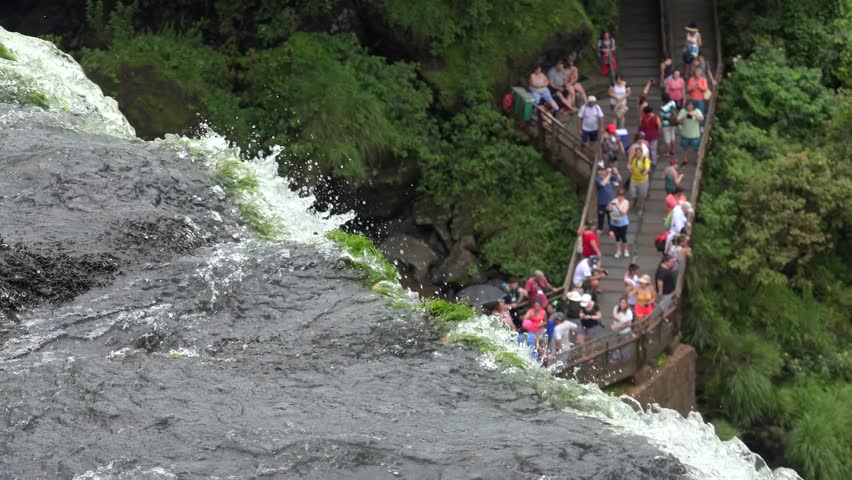 Tourists at the  salto Bossetti observation platform of Iguazu Falls. View from the upper  circuit trail. Argentina.