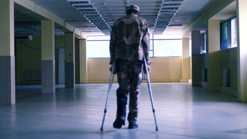 Soldier on crutches with dog in the big hall slow motion shot