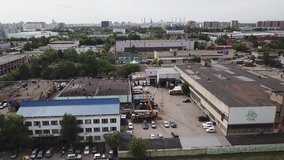 Aerial drone footage over small old soviet industrial zone garages factories facilities construction site  near living quarters in Moscow Russia