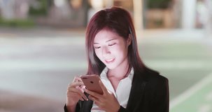 woman use phone in city at night