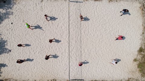 Group of people playing beach volley ball. Aerial vertical view
