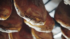 The dried pork thighs hang on the meat market. Prosciutto hanging close up. 4K UHD video 3840x2160. Concept of: tradition, Italy, food, ham.