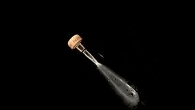 This slow motion video shows hands opening the cork of a bottle of red wine with a black background.