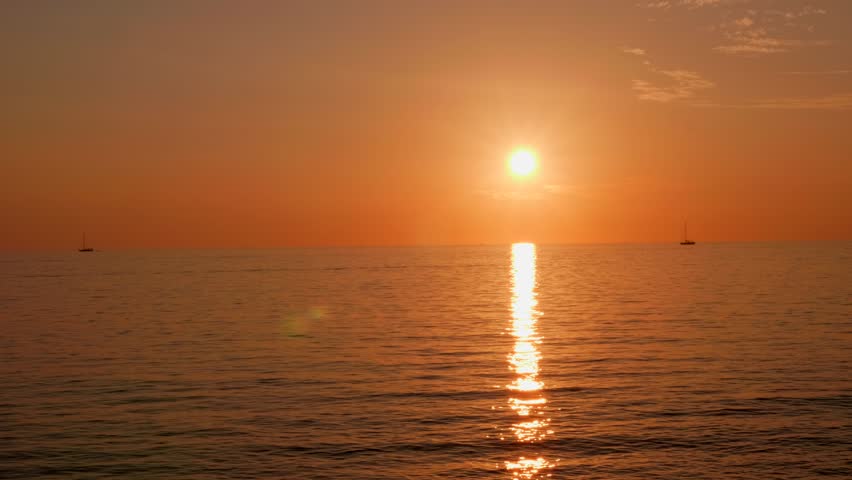 Red orange sunset over the sea ocean whit sail boat in background